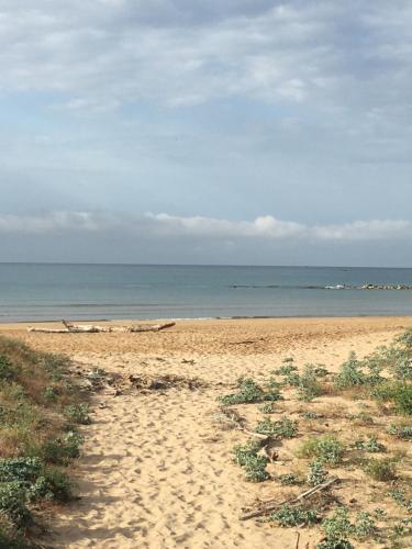 a sandy beach with the ocean in the background at Stella di Mare Guest House Marina di Ragusa in Plaia Grande