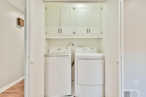a white laundry room with a washer and dryer at Cozy Home with Arcade, Ping Pong & Fenced Backyard in Lawrenceville