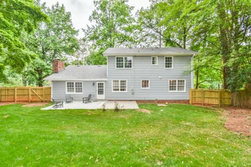 a white house with a fence in a yard at Cozy Home with Arcade, Ping Pong & Fenced Backyard in Lawrenceville