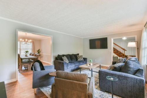 a living room with blue couches and a table at Cozy Home with Arcade, Ping Pong & Fenced Backyard in Lawrenceville
