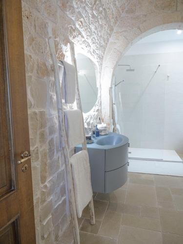 a bathroom with a sink and a stone wall at Casa Pietra Bianca Fay in Castellana Grotte
