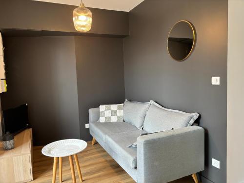 a living room with a couch and a mirror at En si bon chemin - Gîte chemin 65 in Le Monastier sur Gazeille