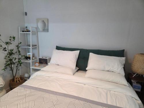 a bed with white pillows in a bedroom at Forest Hangang in Seoul
