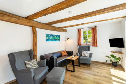 a living room with two chairs and a tv at Fachwerk-Ferienhaus 1764 in Eslohe