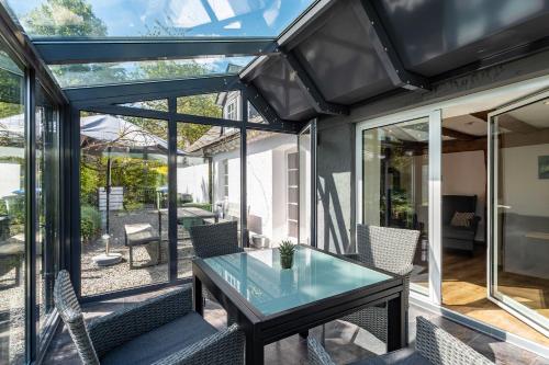 a glass table on the patio of a house at Fachwerk-Ferienhaus 1764 in Eslohe