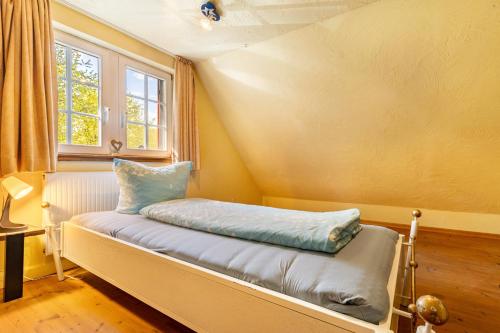 a small bed in a room with a window at Fachwerk-Ferienhaus 1764 in Eslohe