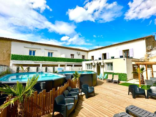 a patio with a pool and chairs and a building at Les Appartements du Mas - Aventurine in Aigues-Mortes