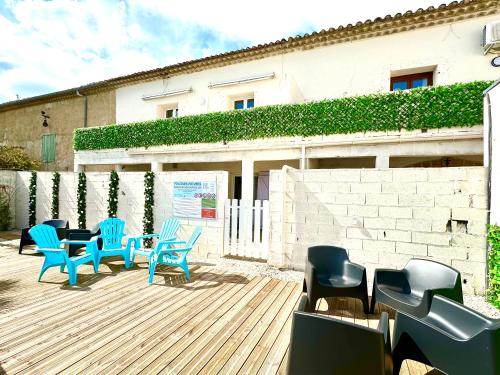 a group of chairs and tables on a wooden deck at Les Appartements du Mas - Aventurine in Aigues-Mortes
