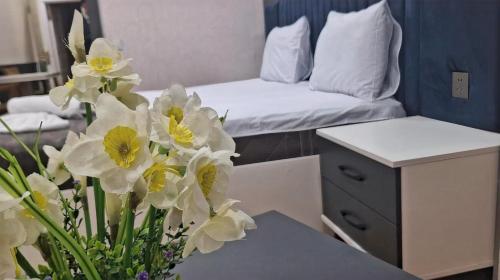a room with a table with a bed and flowers at Nord West Hotel in Baku
