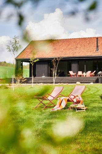 two lawn chairs sitting in the grass in front of a house at Siedlisko Ublik in Wyszowate