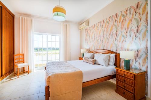 ein Schlafzimmer mit einem Bett und einem großen Fenster in der Unterkunft Filomena Golf Paradise in Guia