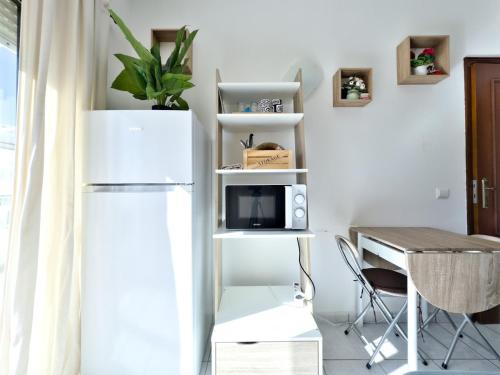a kitchen with a white refrigerator and a table at Room-4-You a 5minutos a pé da praia in Lagos