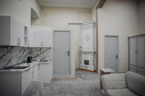 Una sala de estar con un sofá y una cocina. en Old City Home, en Baku