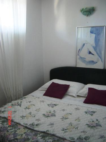 ein Schlafzimmer mit einem Bett und einem Gemälde an der Wand in der Unterkunft Apartment Bella in Split