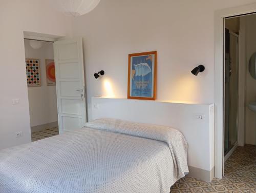 a white bedroom with a bed with lights on it at B&B San Gregorio SINNAI in San Gregorio