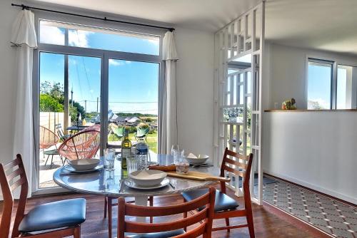 une salle à manger avec une table et des chaises et une grande fenêtre dans l'établissement Le 5 Bel Air à Plogoff., à Plogoff