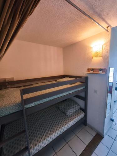 une chambre avec deux lits superposés dans une pièce dans l'établissement Grand studio les pieds dans l'eau, à San-Nicolao