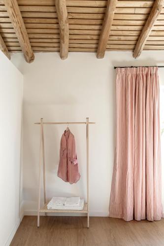 a room with a shelf with a pink jacket on a wall at Casa da Piedade in Marvão