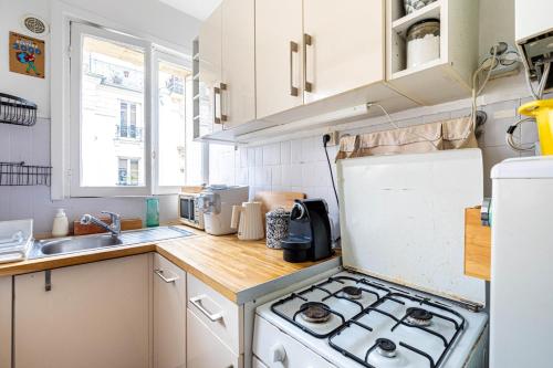 Il comprend une petite cuisine équipée d'une cuisinière et d'un évier. dans l'établissement GuestReady - Charming stay in Chinatown, à Paris