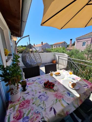 a table on a balcony with food on it at ILOVIK FLOWER in Ilovik