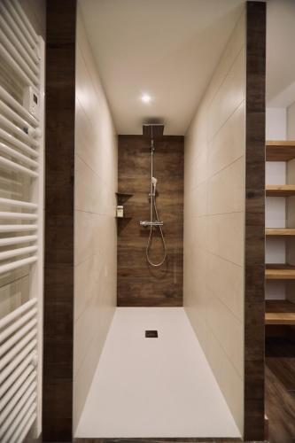La salle de bains en bois est pourvue d'une douche à l'italienne. dans l'établissement Chalet des beauxmonts, à Morillon