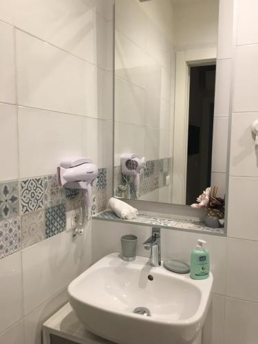 a white bathroom with a sink and a mirror at Armonie di Campagna Rooms & Breakfast di Valentini Sabina in Calderara di Reno
