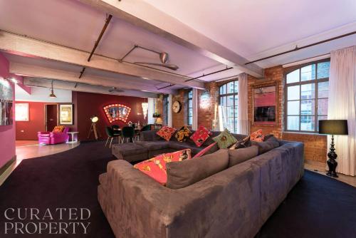 a large living room with a large couch in a room at Amazingly Luxurious Loft Apartment, Soho - 3 Bedrooms, 2 Bath & Office in London