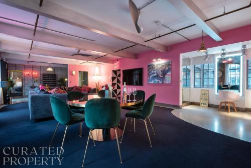 a living room with pink walls and a table and chairs at Amazingly Luxurious Loft Apartment, Soho - 3 Bedrooms, 2 Bath & Office in London