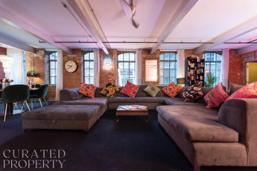 a living room with a couch and a table at Amazingly Luxurious Loft Apartment, Soho - 3 Bedrooms, 2 Bath & Office in London
