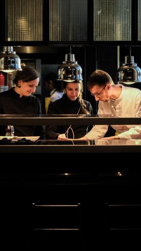 a group of people in a kitchen preparing food at Bienheureux Hôtel & Restaurant in Wasquehal
