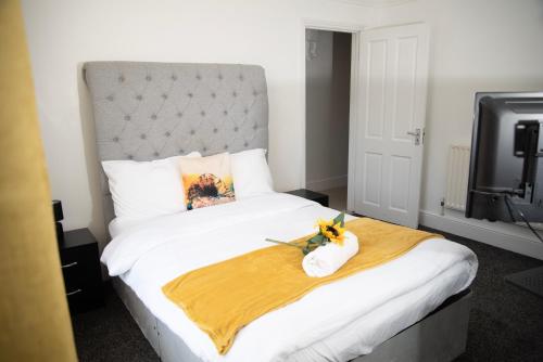 ein Schlafzimmer mit einem großen Bett mit einer Blume darauf in der Unterkunft Kyoto Central I 4 BDR House I 50 inch Smart TVs in Rooms I Large Spacious Rooms I Refurbished I Derby City Centre in Derby