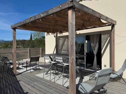 un patio avec une table et des chaises sur une terrasse dans l'établissement la villa des genets, à Saint-Privat