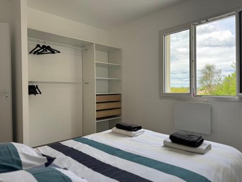 une chambre blanche avec un lit et une fenêtre dans l'établissement la villa des genets, à Saint-Privat