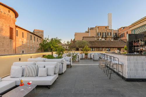 a row of white couches on a rooftop patio at Room Mate Collection Mia, Rome Colosseum in Rome