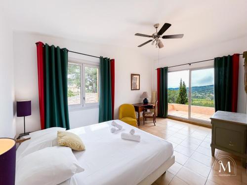 une chambre avec un lit et une grande fenêtre dans l'établissement Belle demeure dans les hauteurs d'Ollioules, à Ollioules