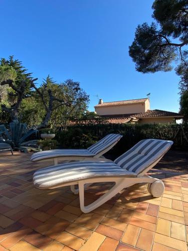 - deux chaises longues assises sur une terrasse dans l'établissement St Raphaël Boulouris maison bord de mer Damalix, à Saint-Raphaël