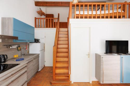 a kitchen with a staircase leading up to a loft at L'Eden Vert Bagnols En Foret YourHostHelper in Bagnols-en-Forêt