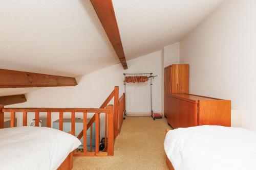 a attic bedroom with two beds and a staircase at L'Eden Vert Bagnols En Foret YourHostHelper in Bagnols-en-Forêt