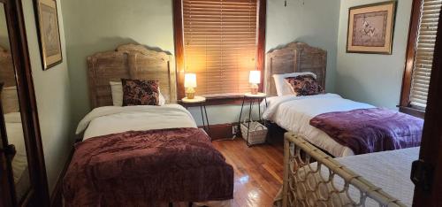 a room with two beds and a window with two lamps at Small-town bungalow downtown in Pineville