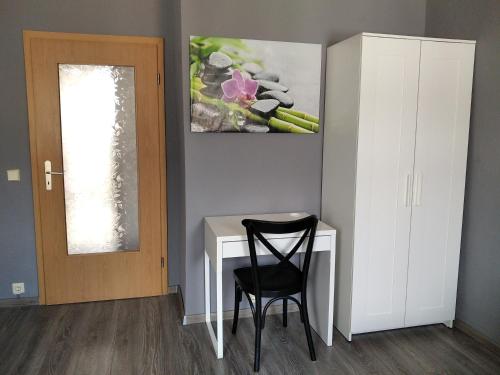 a desk with a chair and a painting on the wall at Monteurwohnung Lugau in Lugau