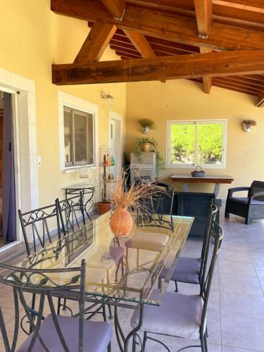 a dining room with a glass table and chairs at Villa des Antonins in Saint-Gilles