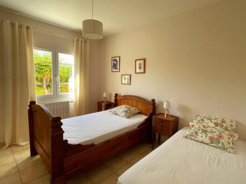 a bedroom with two beds and a window at Villa des Antonins in Saint-Gilles