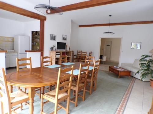 - une salle à manger et un salon avec une table et des chaises en bois dans l'établissement Le Logis de la Venise Verte, à Saint-Hilaire-la-Palud