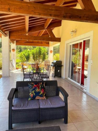 a couch on a patio with a table and chairs at Villa des Antonins in Saint-Gilles