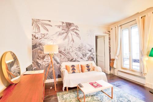 un salon avec une chaise blanche et une fresque de palmier dans l'établissement Le Romantisme à la Française, à Paris