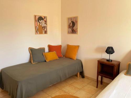 a room with a bed with colorful pillows on it at Villa des Antonins in Saint-Gilles
