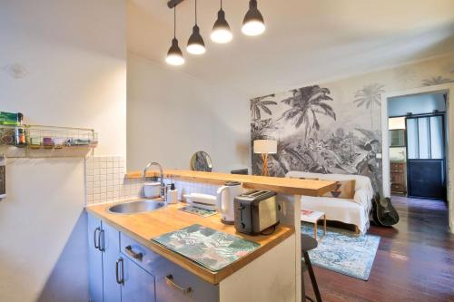 une cuisine avec un évier et un salon dans l'établissement Le Romantisme à la Française, à Paris