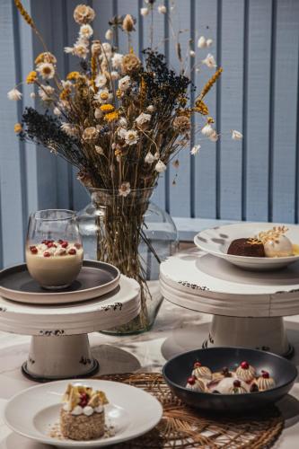 a table with plates of food and a vase with flowers at Hotel Puerta del Sur in Valdivia