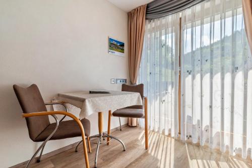 a room with a table and chairs and a large window at Gästehaus Gerda in Bad Peterstal-Griesbach