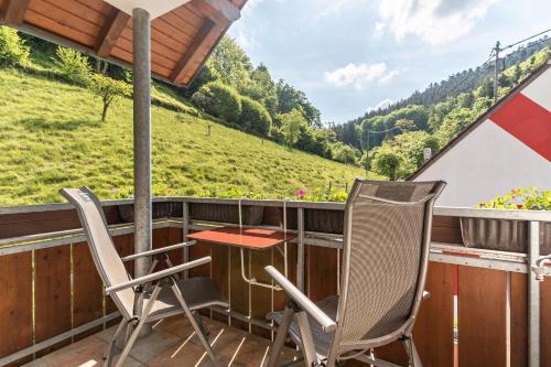 a table and chairs on a balcony with a view at Gästehaus Gerda in Bad Peterstal-Griesbach
